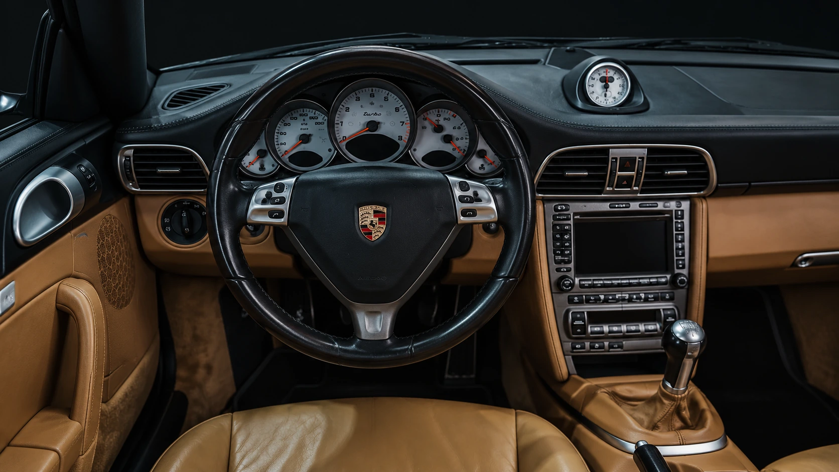 Vista cercana del volante Porsche y del cuadro de instrumentos